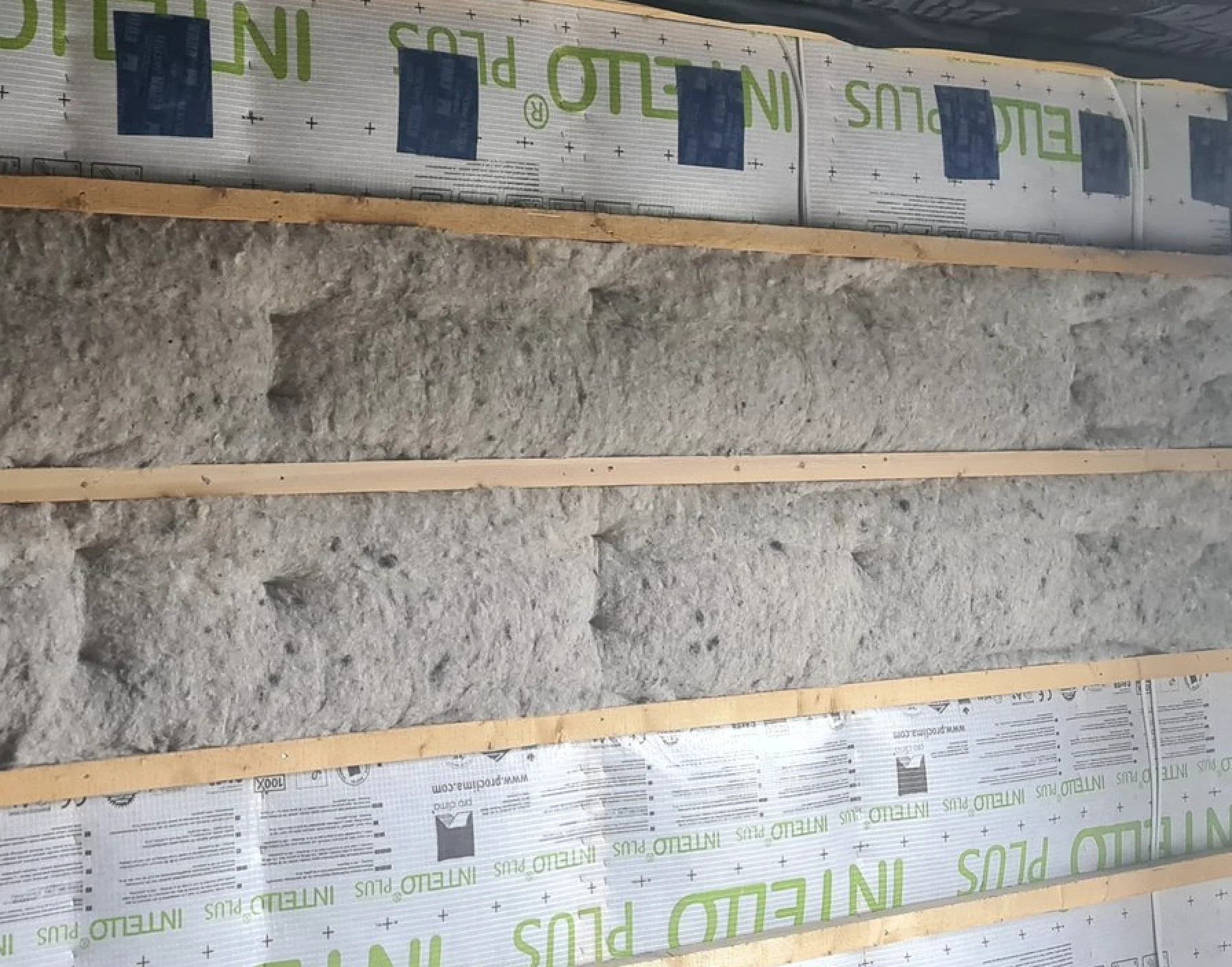 Muur geïsoleerd met cellulose achter een dampscherm, tussen houten latten