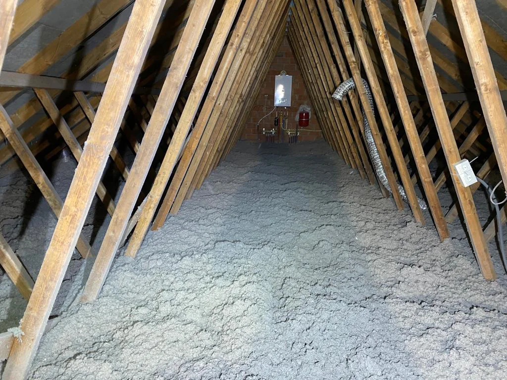 Zolder met een open balklaag, volledig bedekt met losgeblazen cellulose